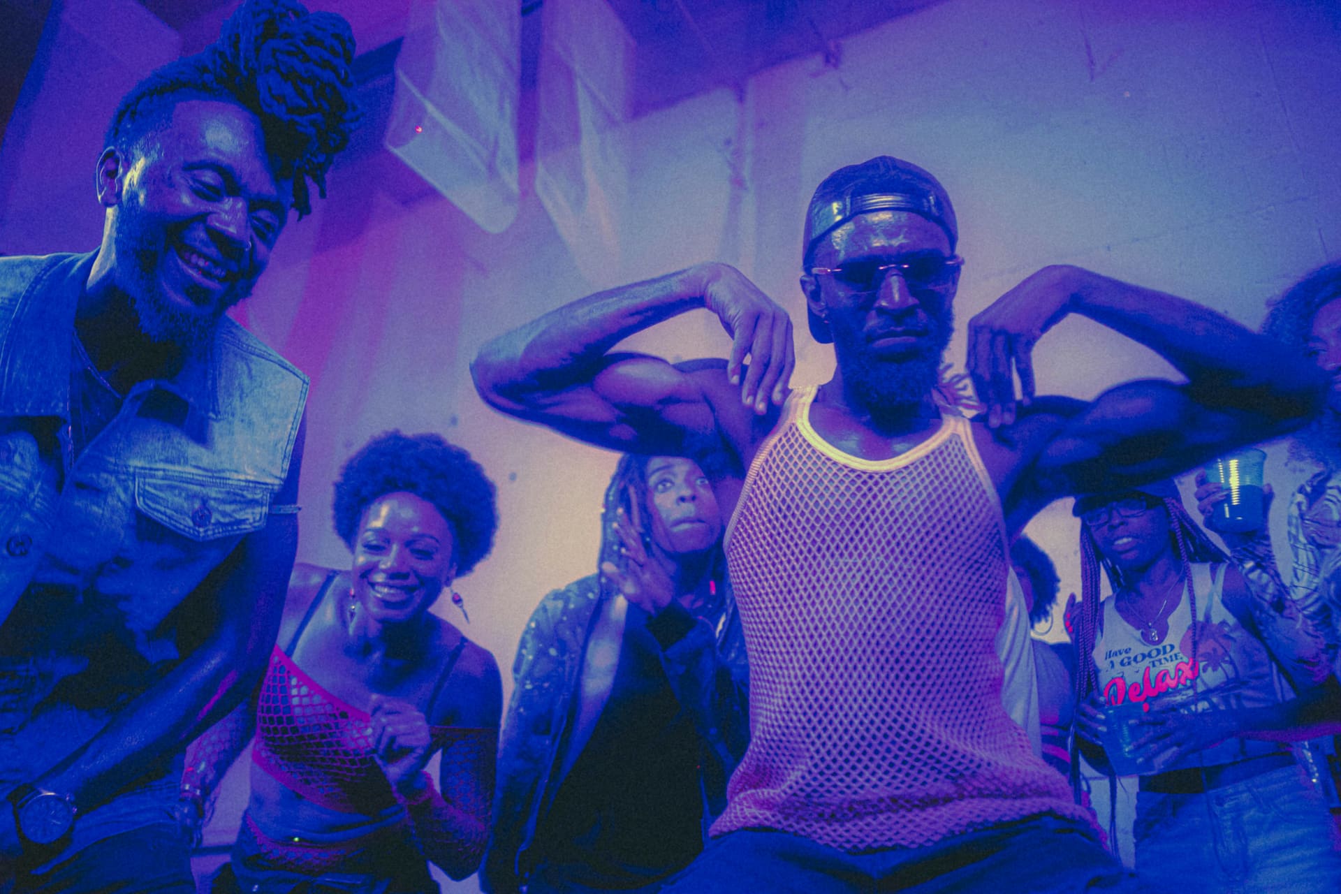 A crowd lit in violet and pink at a NuVision activation